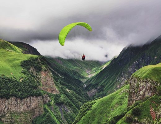 person paragliding near mountain range